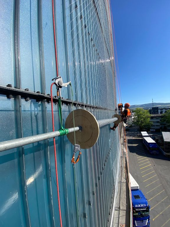 Abrollen des Stahlnetzes an der Fassade